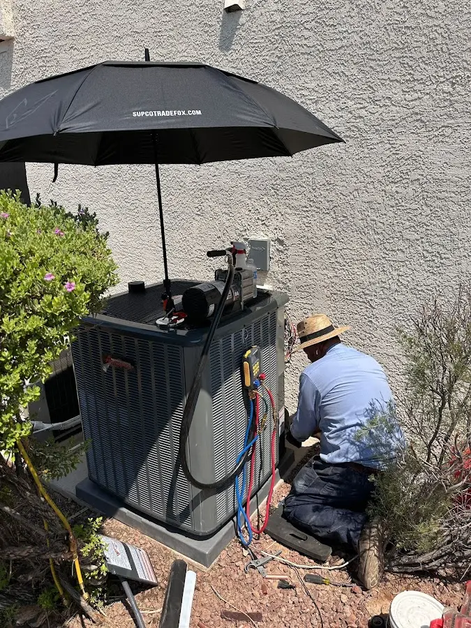 HVAC technician performing outdoor AC maintenance in Antrim
